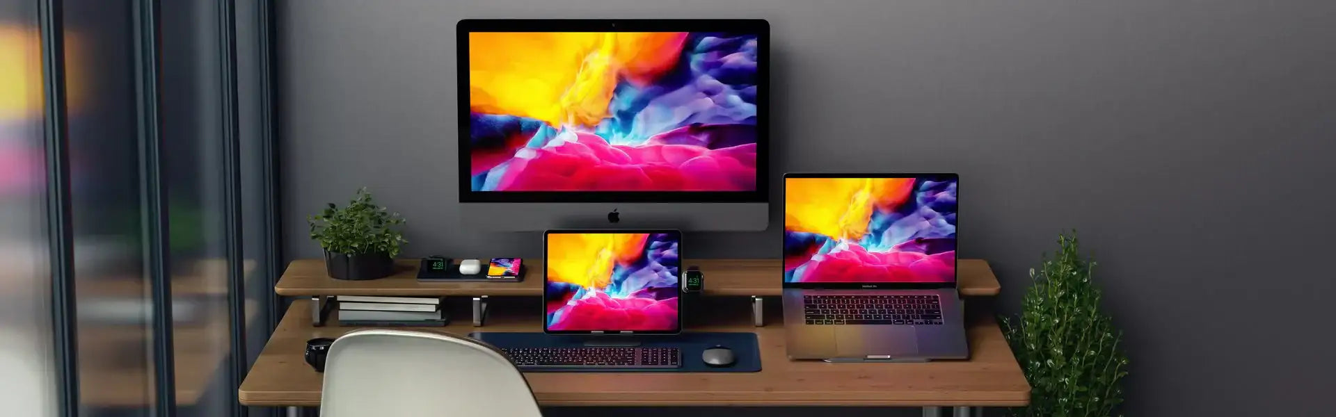 Biurko z komputerem iMac, laptopem MacBook, tabletem iPhone, Apple Watch i roślinami