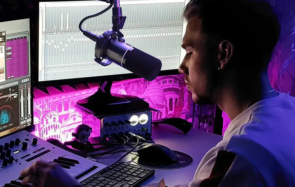 Mężczyzna nagrywający podcast w studio z mikrofonem, mikserem audio i ekranami komputerowymi