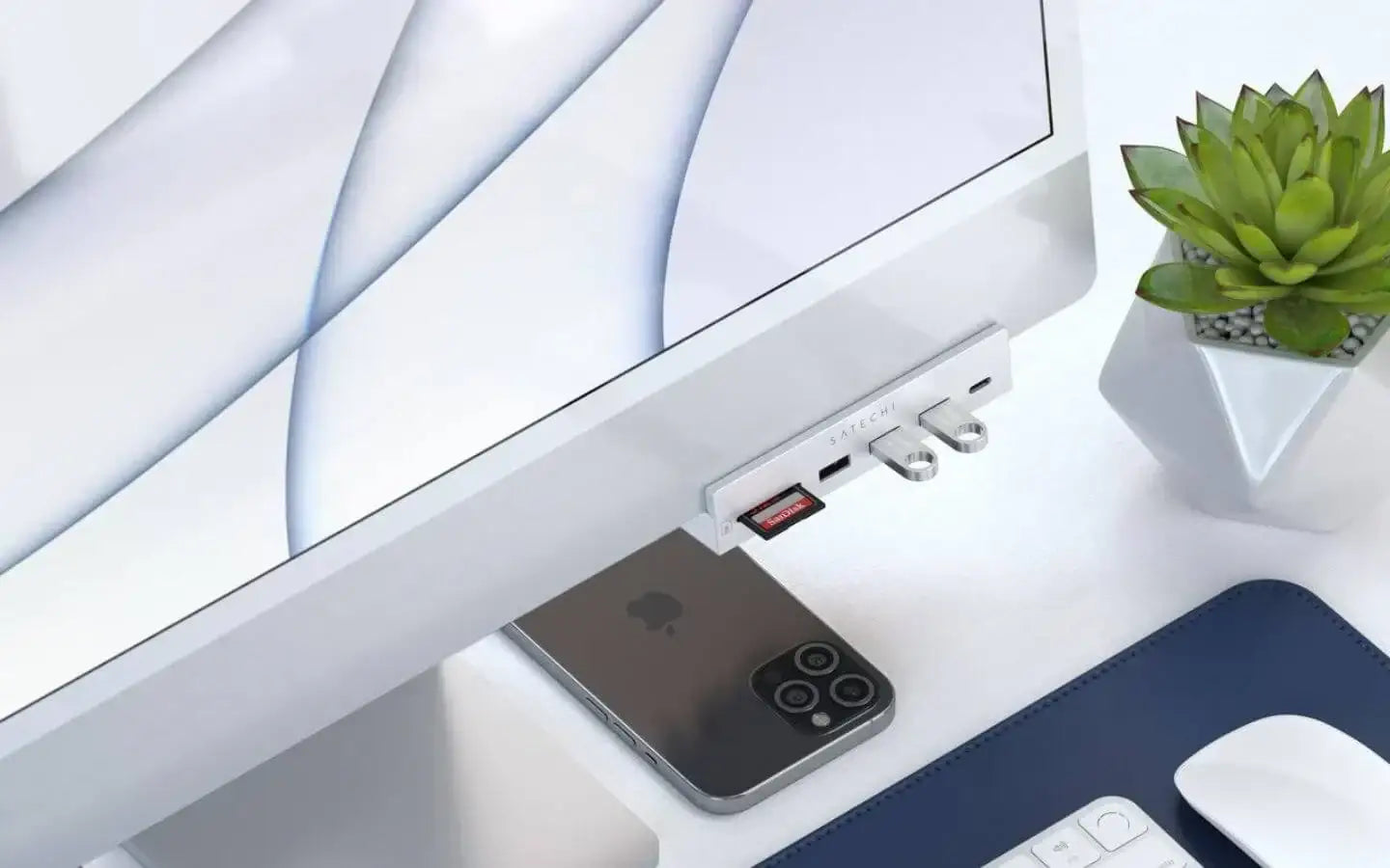 Nowoczesne biurko z komputerem iMac, czytnik kart pamięci Satechi, smartfon iPhone, biała klawiatura, mysz i sukulent