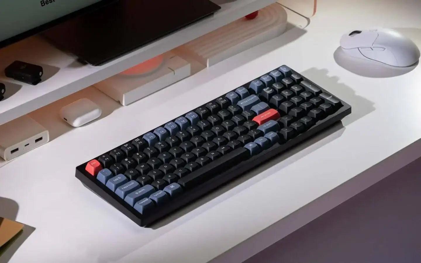 Klawiatura mechaniczna na białym biurku obok białej myszy i akcesoriów komputerowych