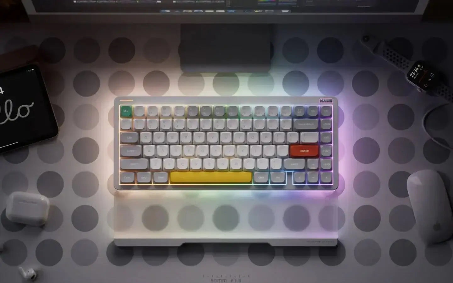 Klawiatura mechaniczna z podświetleniem RGB na biurku z tabletem, smartwatchem i akcesoriami Apple