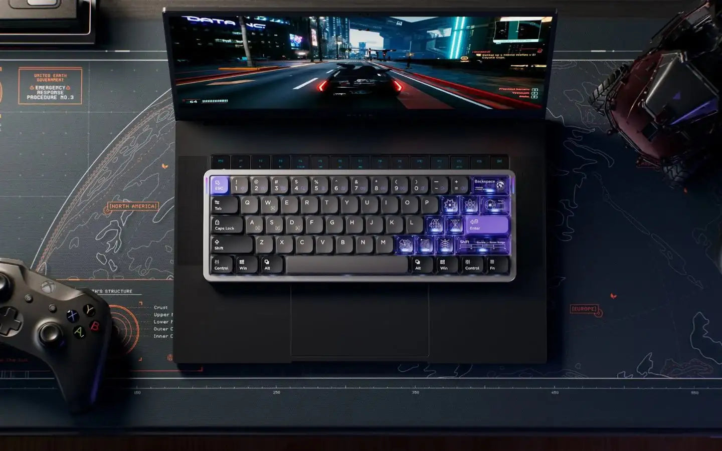 Laptop z mechaniczną podświetlaną klawiaturą i symulatorem wyścigów na ekranie, kontroler Xbox obok