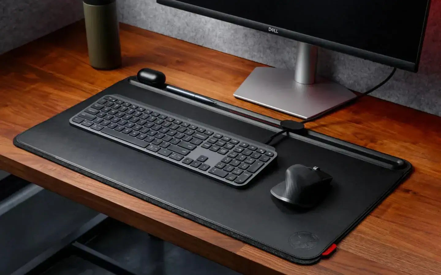 Ergonomiczne stanowisko pracy z czarną klawiaturą, myszką i podkładką na drewnianym biurku