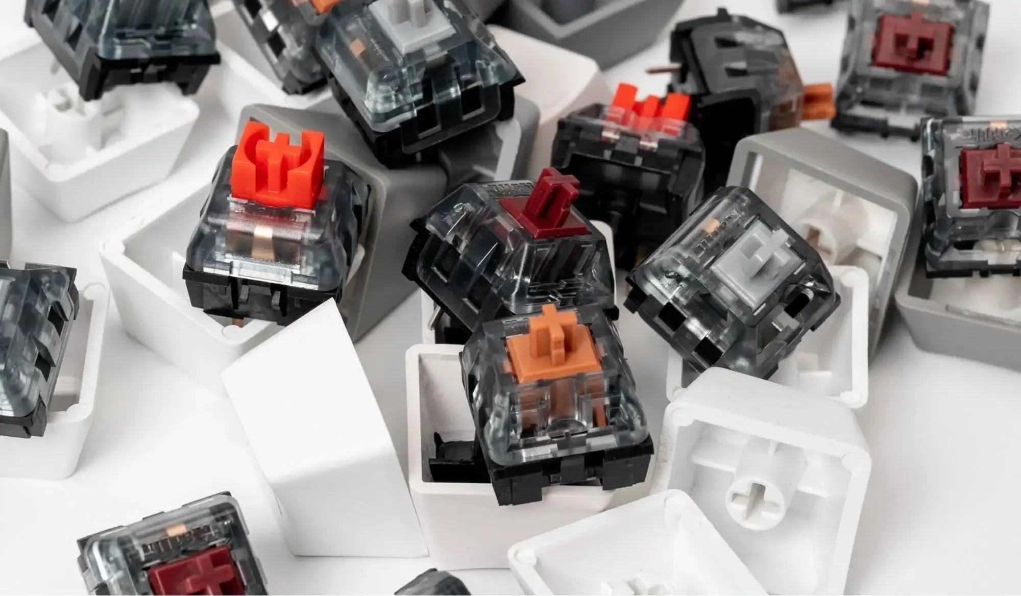 Różnokolorowe klawiaturowe przełączniki mechaniczne Kailh z białymi keycapami na białym tle