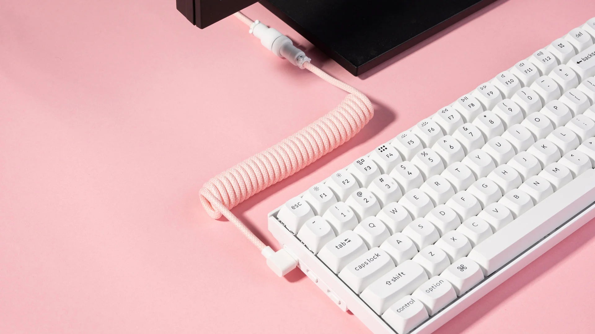 Biała klawiatura mechaniczna z różowym spiralnym kablem USB-C na różowym tle