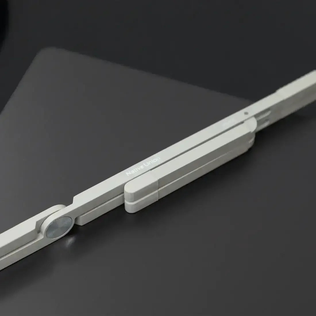 Minimalistyczny składany stojak na laptopa Native Union w kolorze piaskowym na czarnym tle