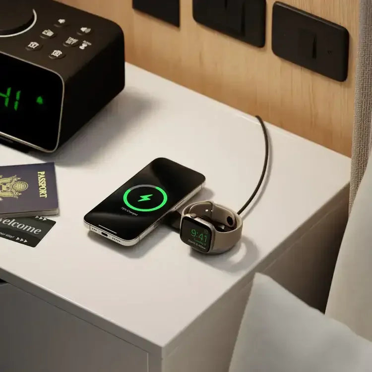 Smartfon i smartwatch na ładowarce indukcyjnej na stoliku nocnym w hotelu