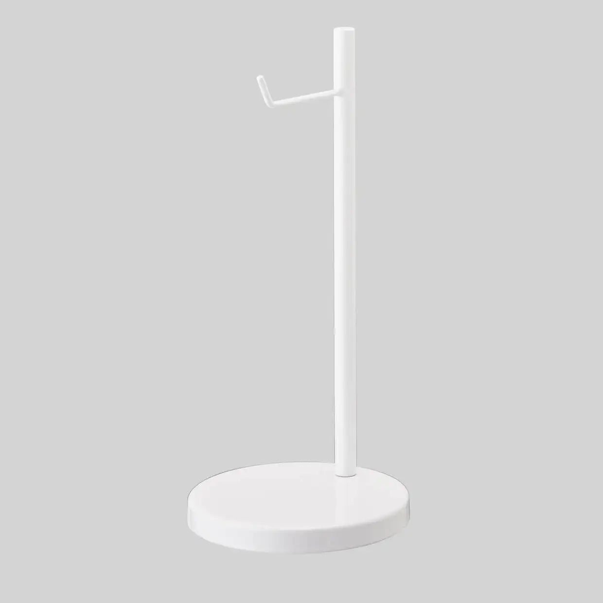 Biały stojak na słuchawki z okrągłą podstawą na szarym tle