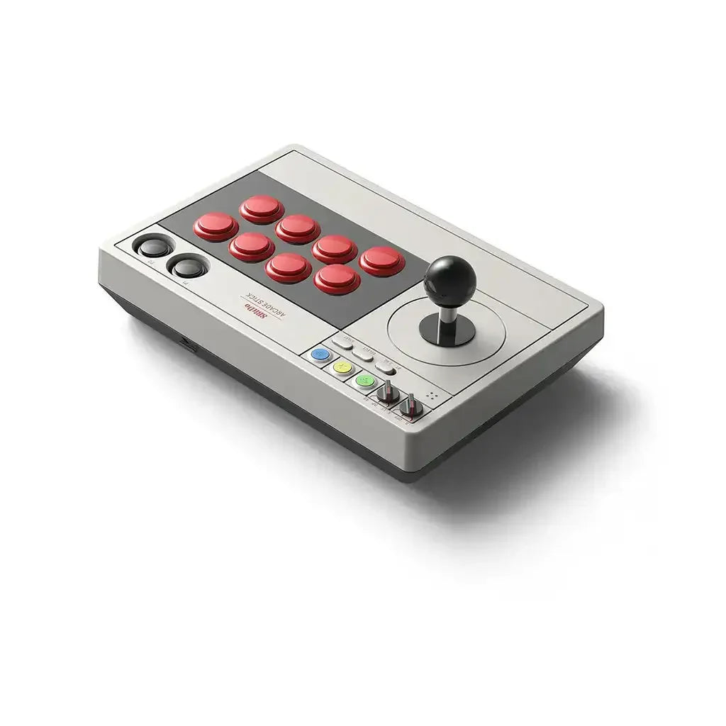 Arcade stick z joystickiem, czerwonymi przyciskami i szarą obudową na białym tle