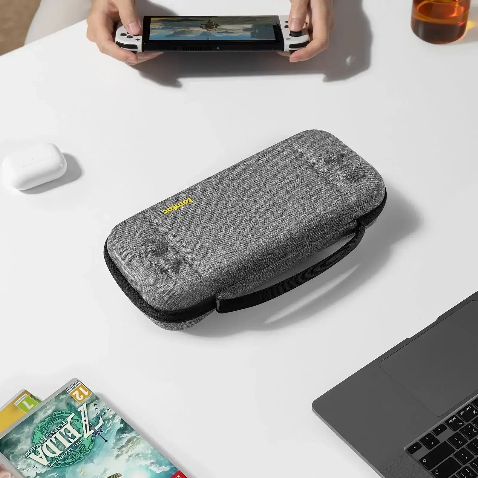Szare etui na konsolę Nintendo Switch na biurku, akcesoria gamingowe, setup biurowy