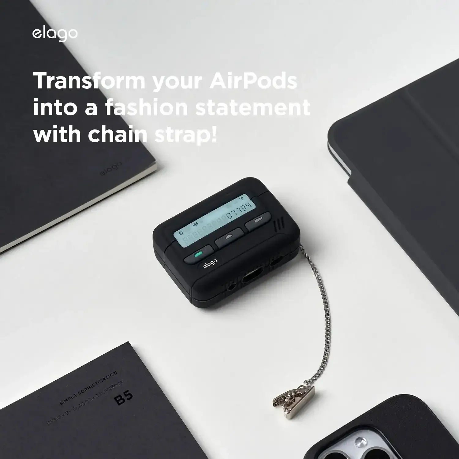Czarny futerał na AirPods w stylu pagera z łańcuszkiem na biurku obok notebooka i telefonu