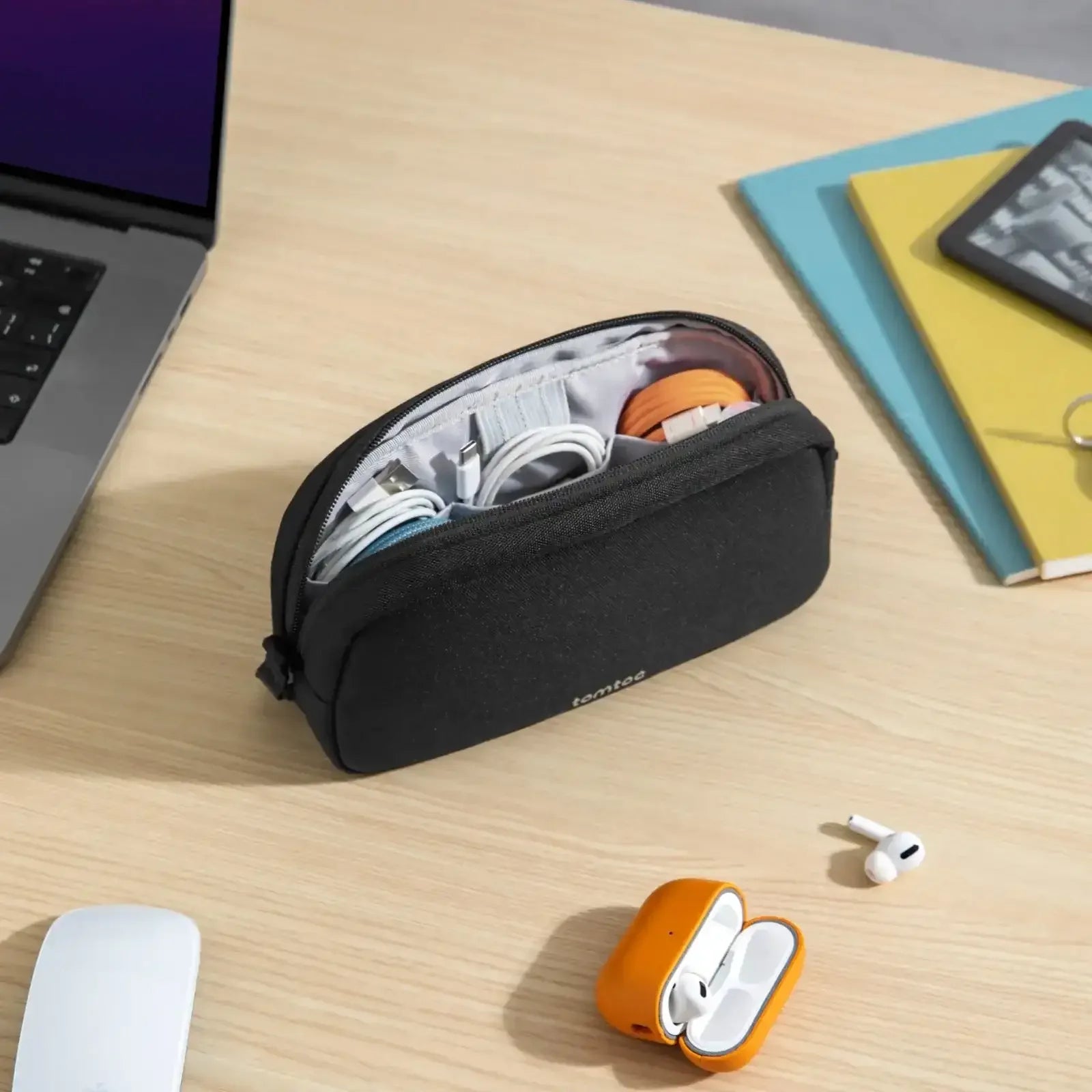 Etui na akcesoria biurowe i kable na biurku obok laptopa i słuchawek bezprzewodowych