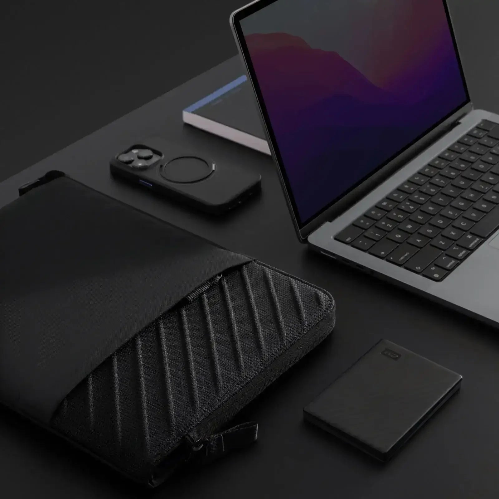 Nowoczesny setup biurowy, laptop, etui ochronne, smartfon, zewnętrzny dysk, minimalistyczne akcesoria