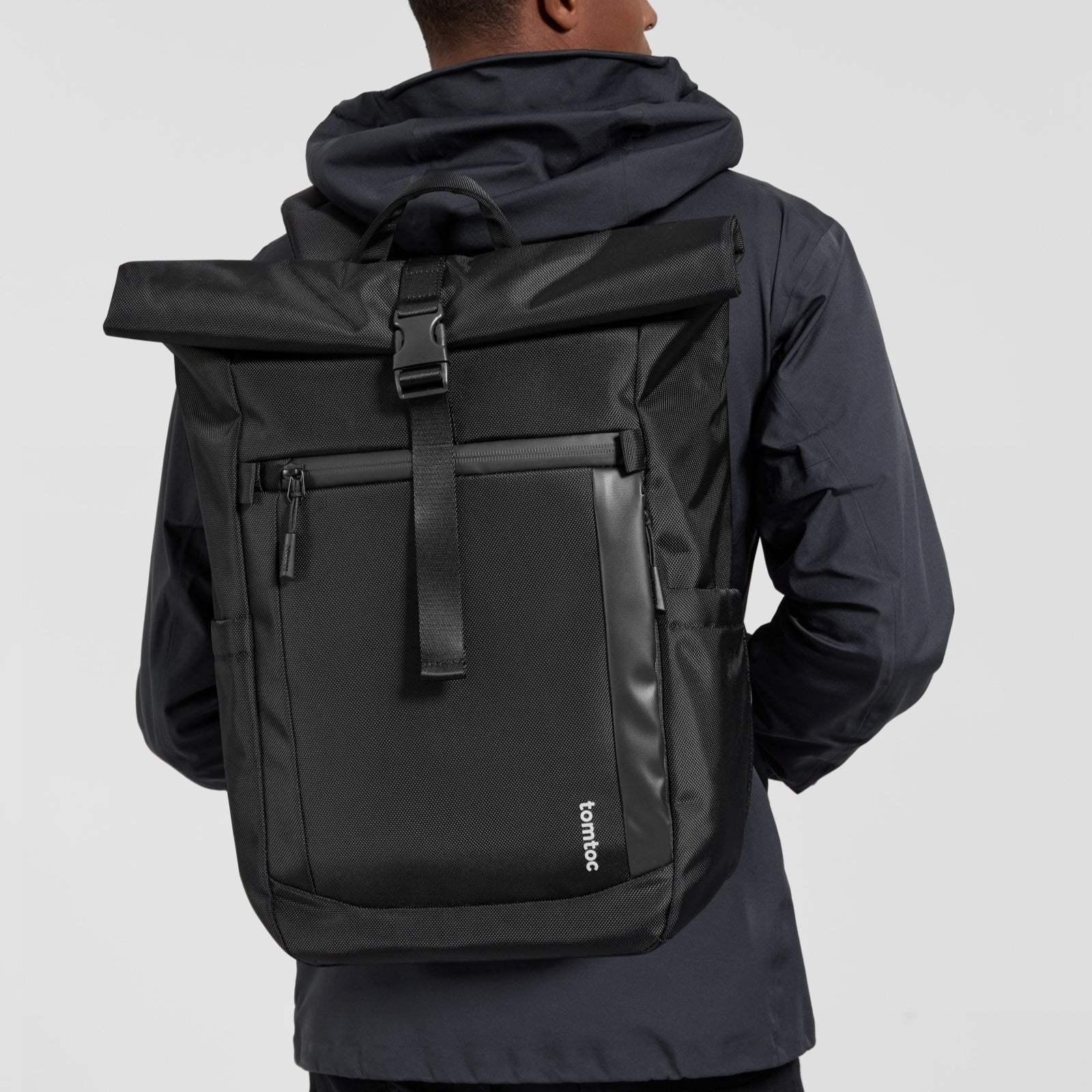 Czarny plecak na laptopa typu rolltop, mężczyzna w kurtce, nowoczesny design