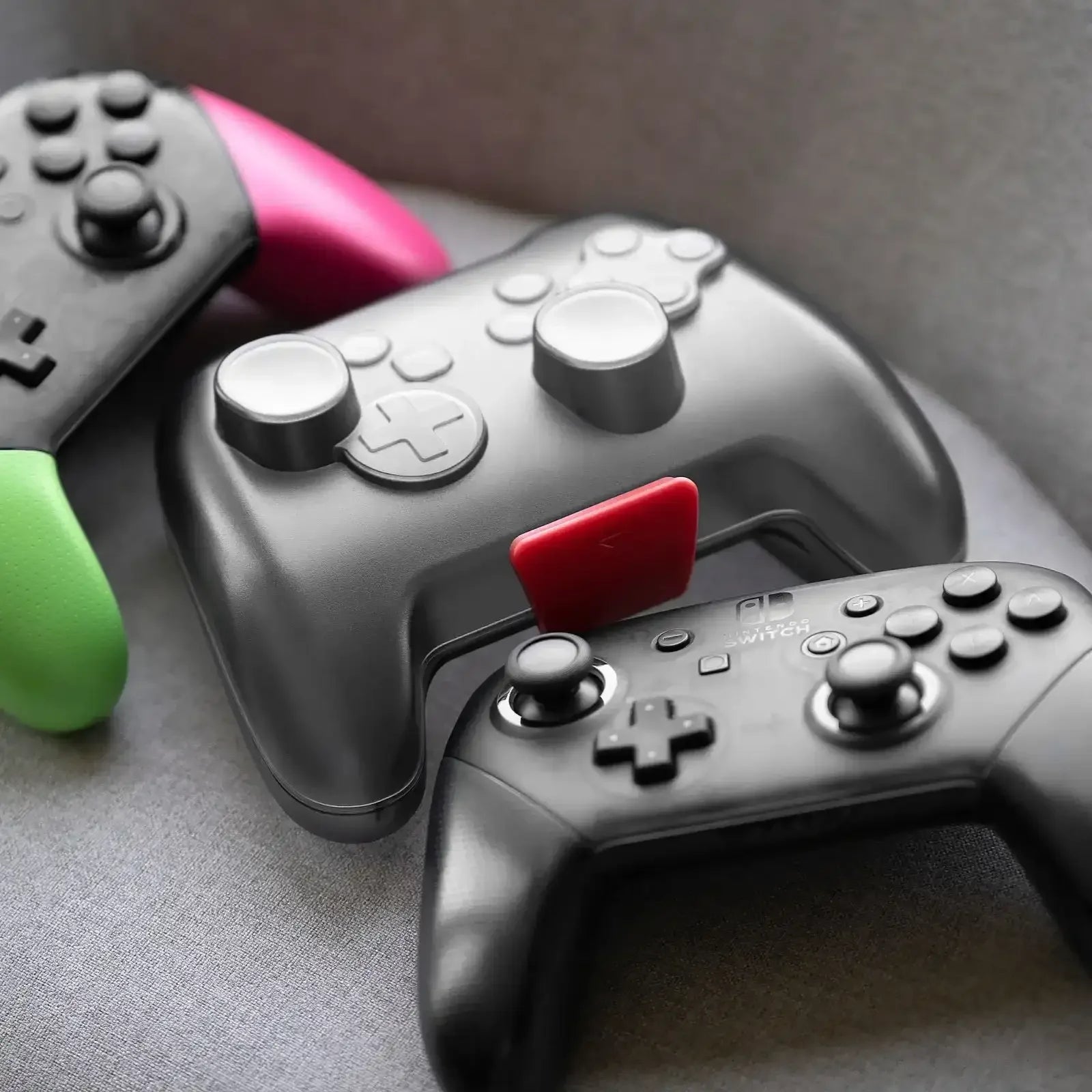 Kolorowe kontrolery do gier z przyciskami i joystickami na szarej powierzchni