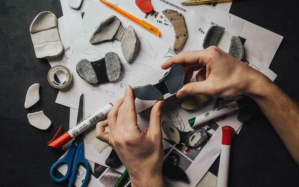 Prototypy ergonomicznych akcesoriów biurowych, projektowanie na biurku z narzędziami.