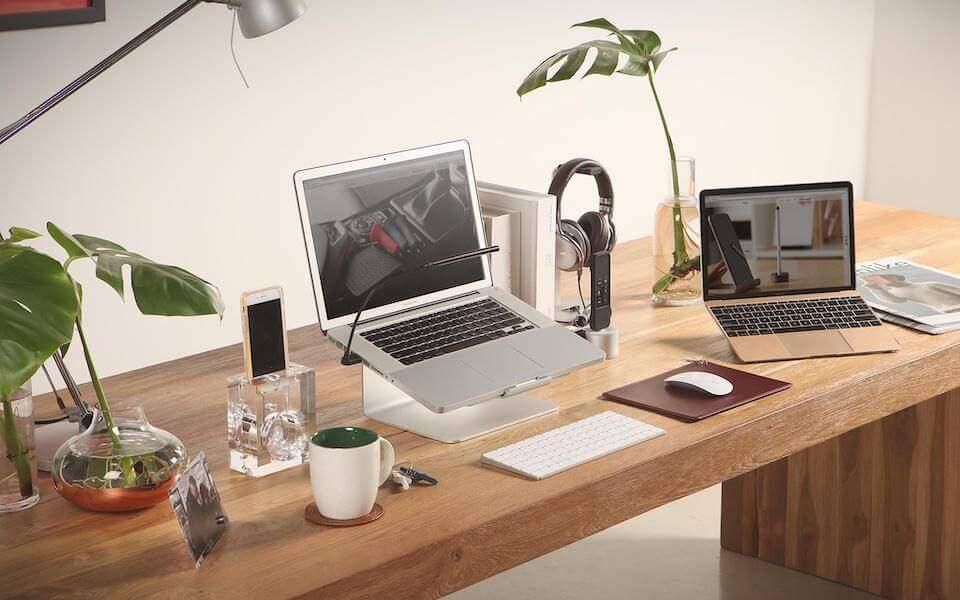 Nowoczesne biurko do home office z laptopami, klawiaturą mechaniczną, myszą, akcesoriami i roślinami