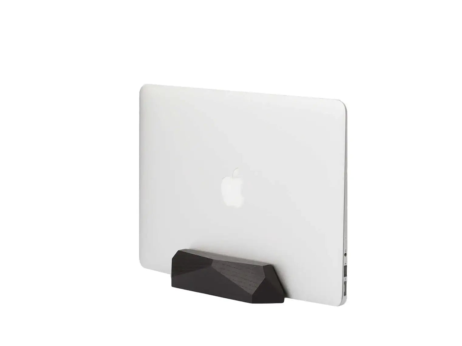 Biały laptop Apple w czarnej, geometrycznej podstawce na białym tle