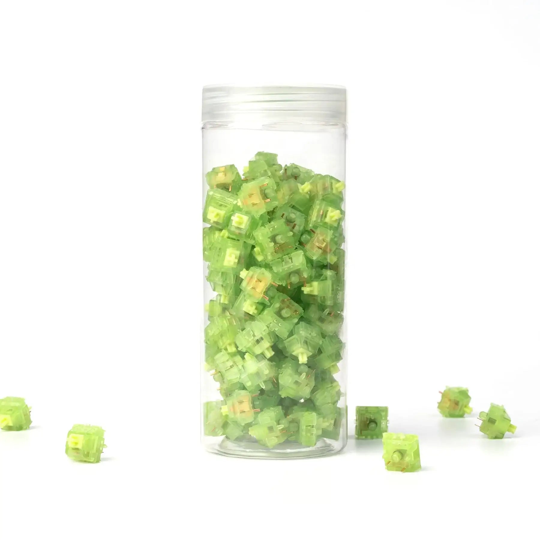 Zielone przełączniki Gateron Luciola Linear w przezroczystym pojemniku na białym tle