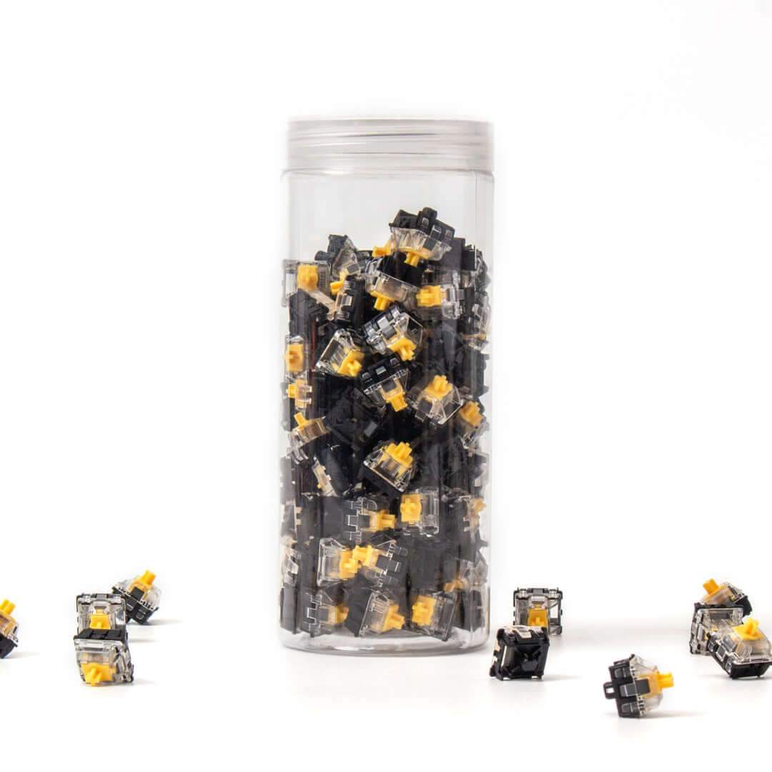 Przezroczysty słoik z żółtymi przełącznikami Gateron Optical na białym tle