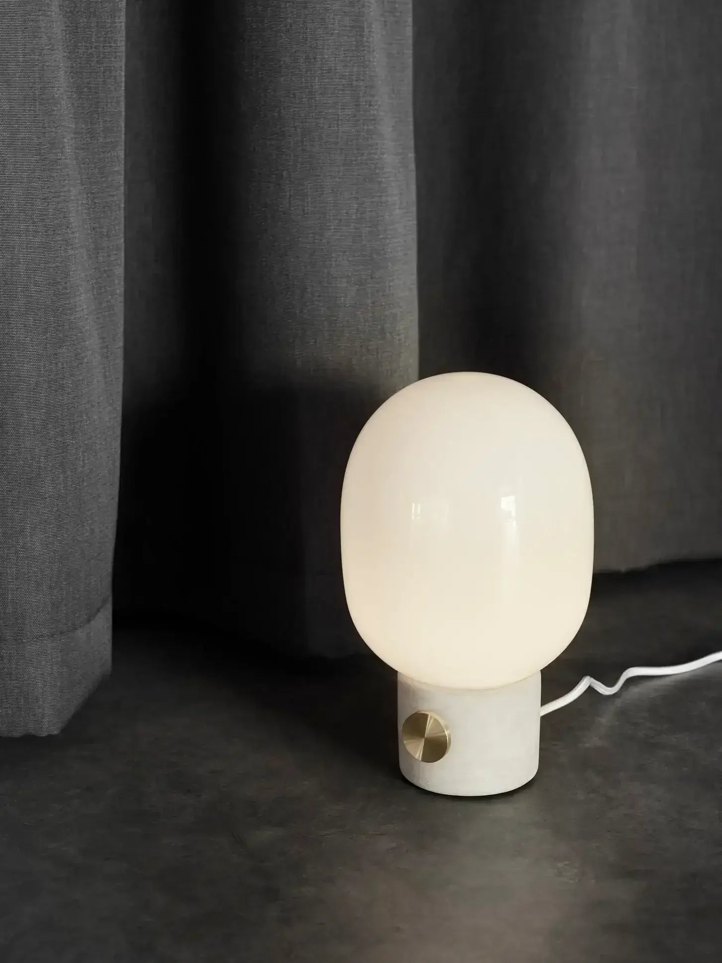 Nowoczesna lampka biurkowa z matowym kloszem na marmurowej podstawie, idealna do home office
