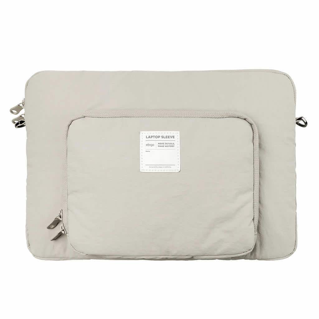 Szara torba na laptopa z dużą kieszenią na akcesoria, minimalistyczny design.