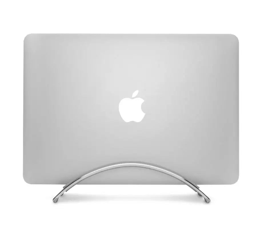 Srebrny MacBook w pozycji pionowej na aluminiowej podstawce, logo Apple, minimalistyczne biurko.