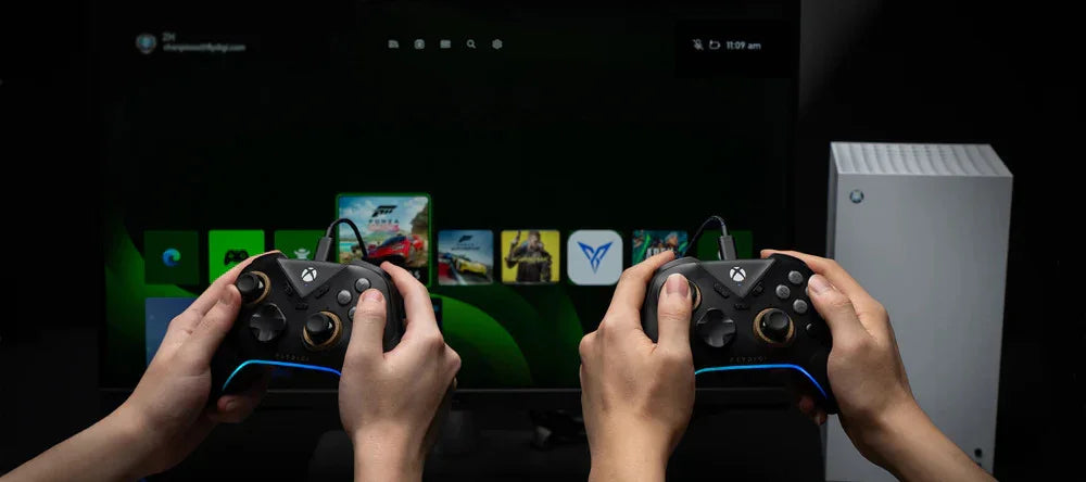 Dwie ręce trzymają czarne kontrolery Xbox z niebieskim podświetleniem, przed ekranem z menu gier i konsolą Xbox Series S.