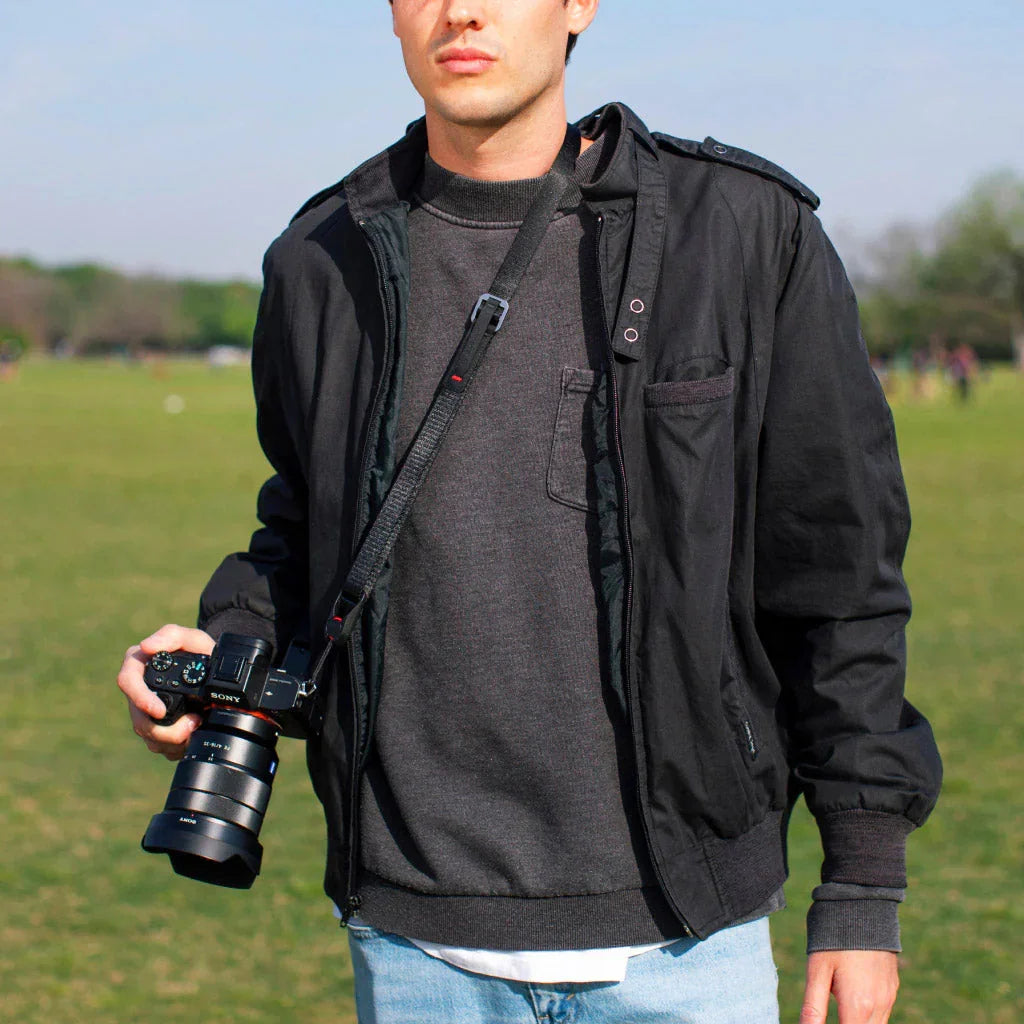 Mężczyzna z aparatem Sony na zewnątrz, idealny dla fotografów i entuzjastów