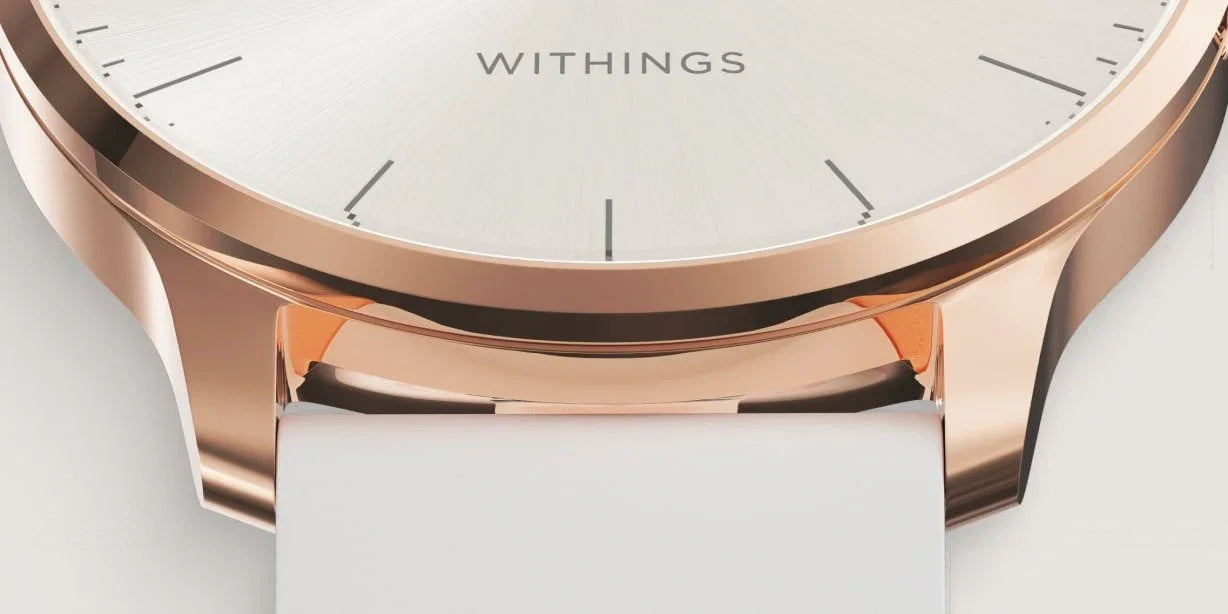 Zegarek Withings z różowozłotą obudową i białym paskiem, elegancki design do stylowego biurka