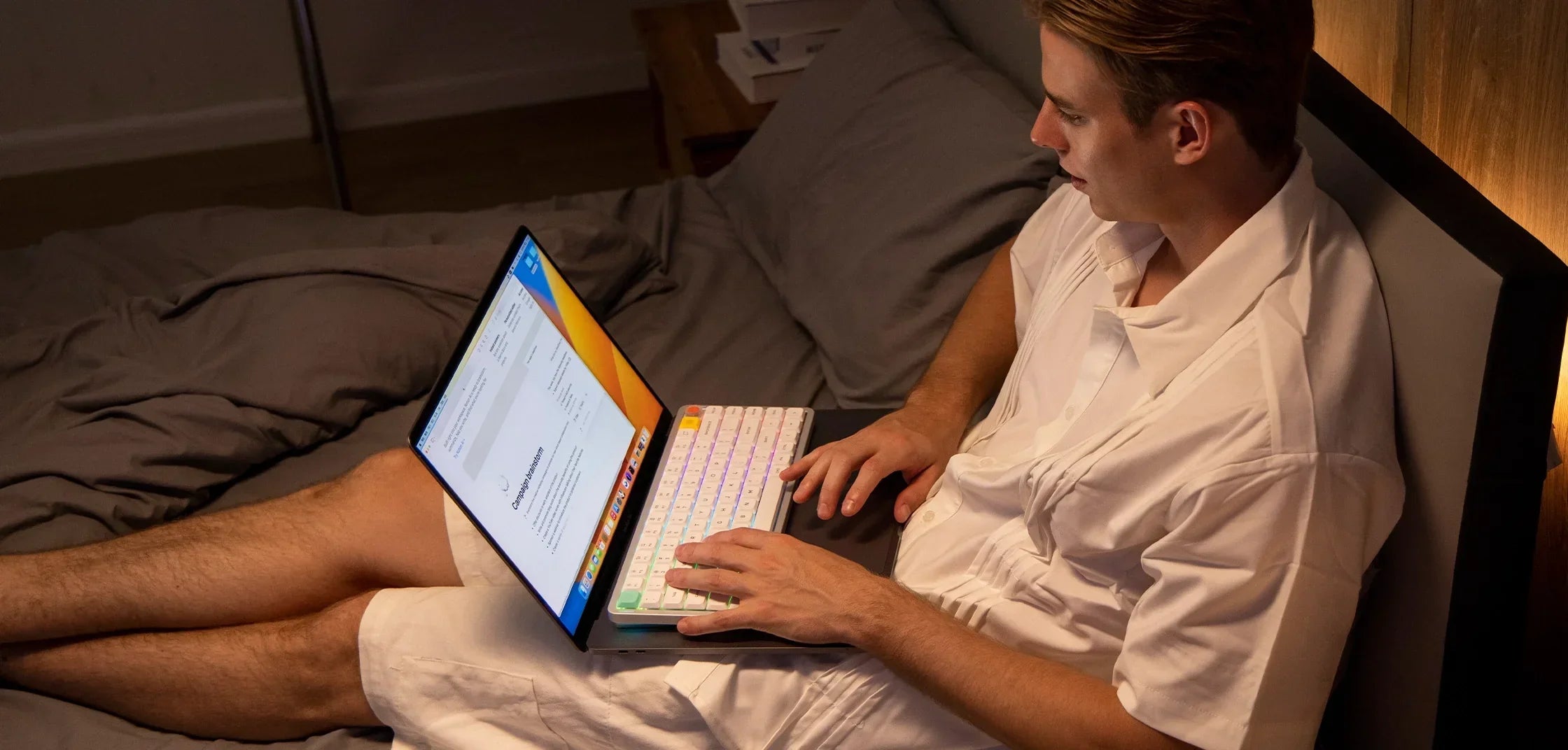 Mężczyzna używa klawiatury mechanicznej z RGB na laptopie w domowym biurze