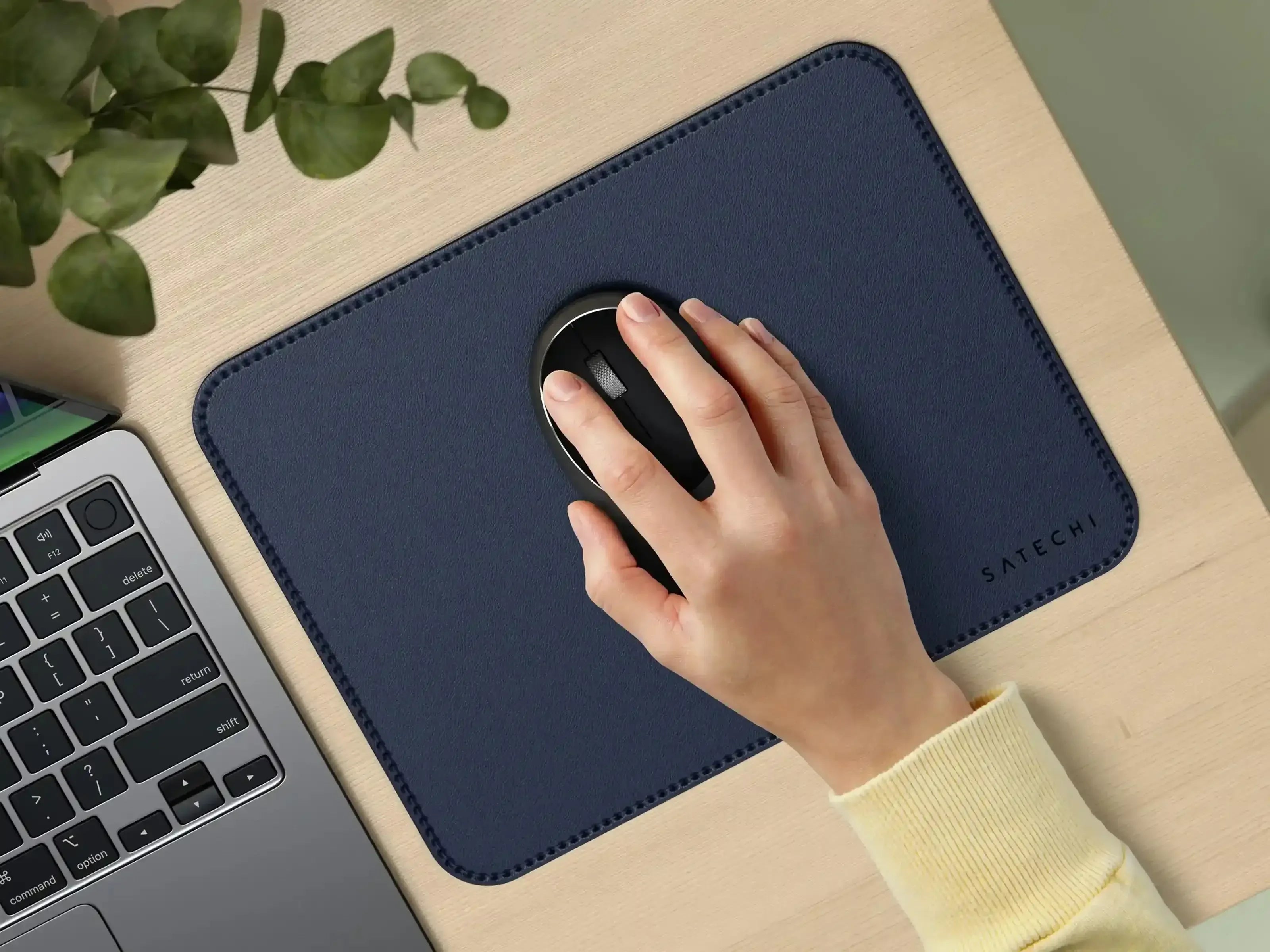 Granatowa podkładka pod mysz ze skóry wegańskiej na biurku obok laptopa, ręka na myszy