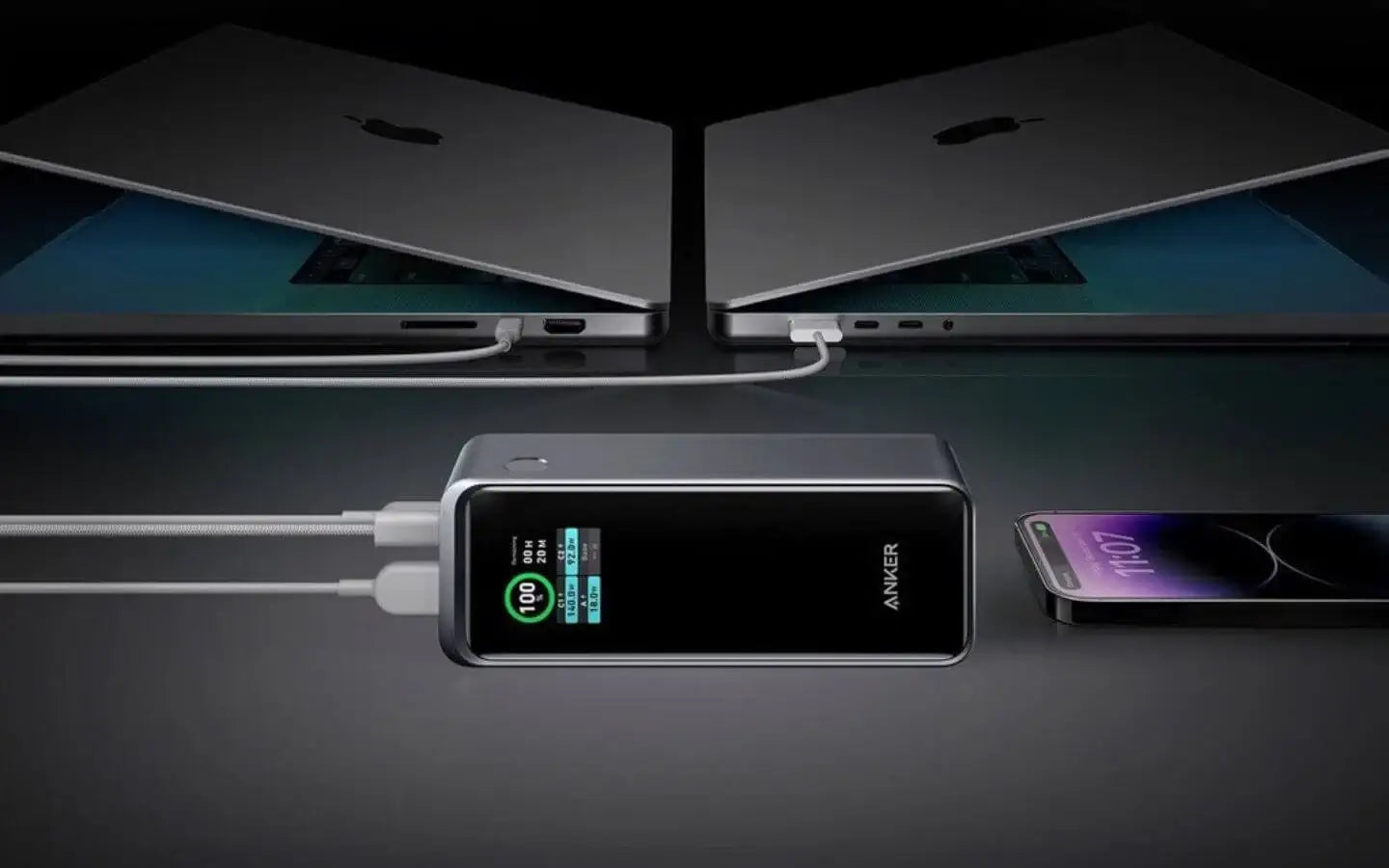 Powerbank Anker z ekranem LCD ładowanie dwóch laptopów i smartfona na czarnym tle