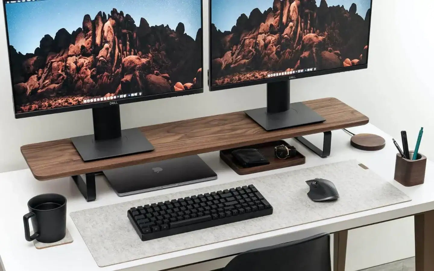 Minimalistyczne biurko z dwoma monitorami Dell, klawiaturą, myszką i akcesoriami do pracy