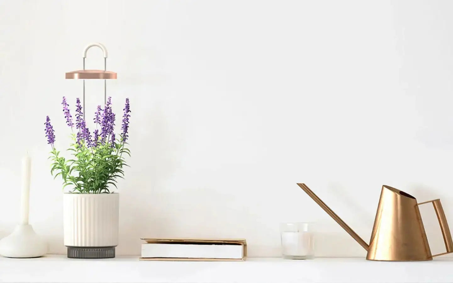 Lawenda w doniczce, biała świeca, książka i miedziany dzbanek na białej półce minimalistyczny wystrój