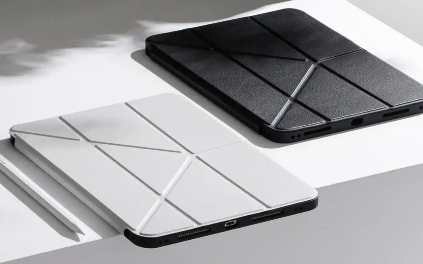 Etui na tablet w kolorze białym i czarnym z geometrycznym wzorem, leżące na białej powierzchni