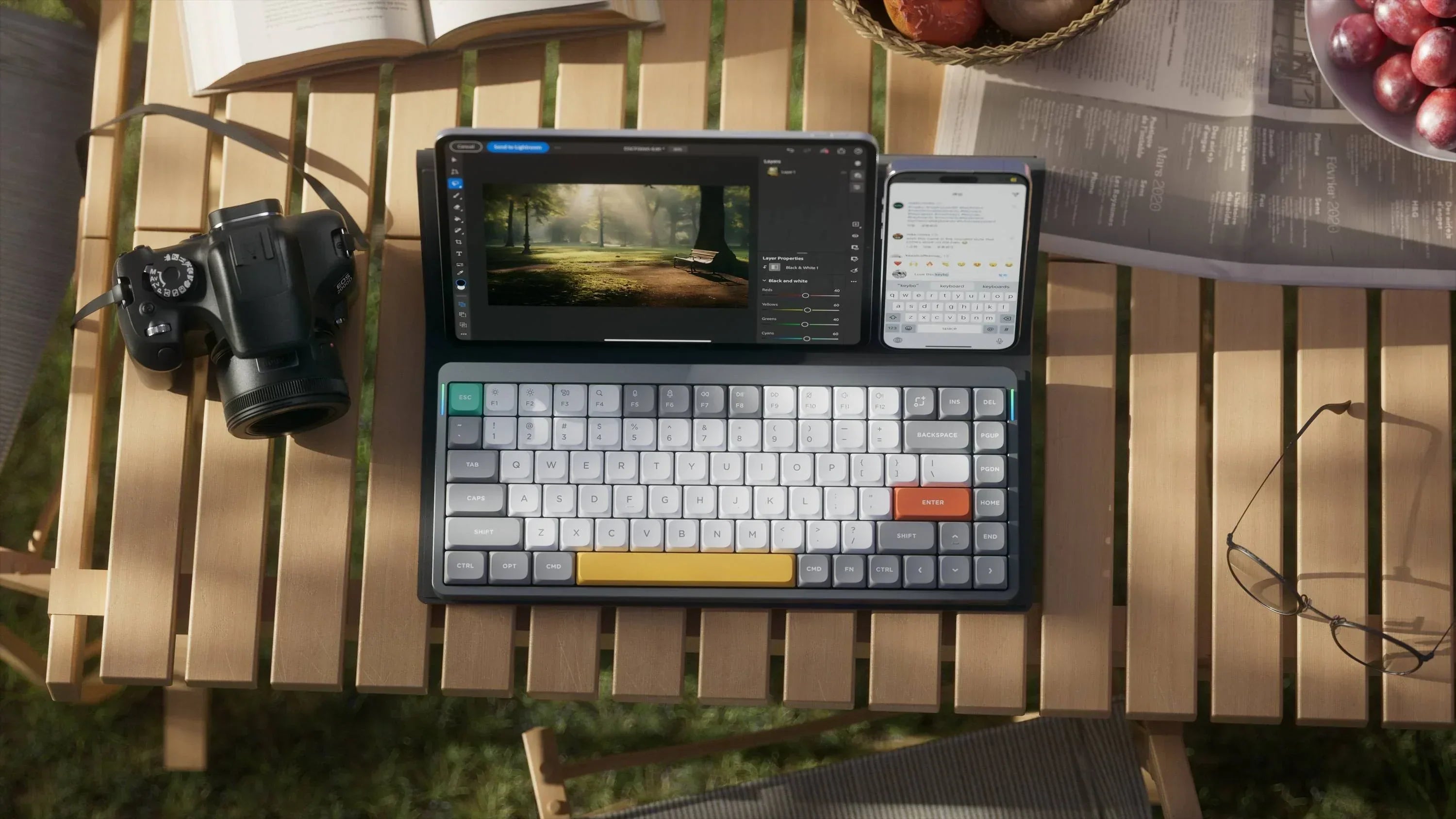 Laptop z cyfrową edycją zdjęć, aparat fotograficzny, okulary i gazeta na drewnianym stole na zewnątrz