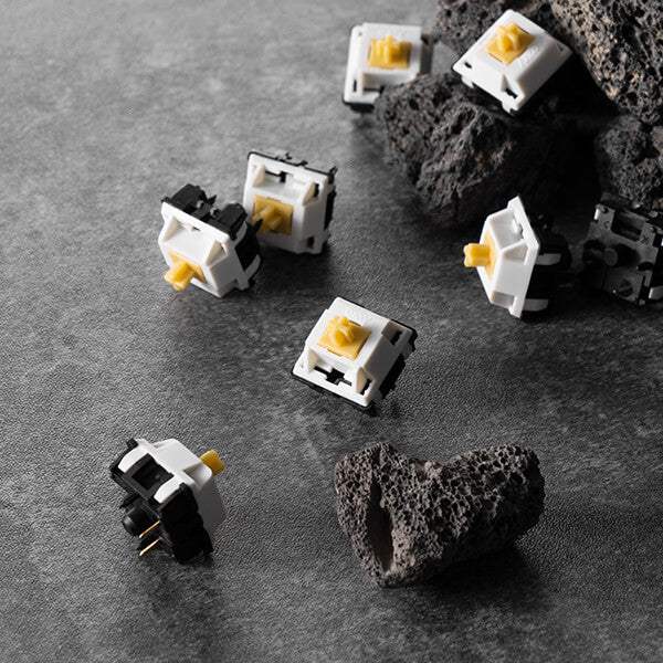 Przełączniki do klawiatury mechanicznej z żółtym trzpieniem na tle kamieni, akcesoria komputerowe