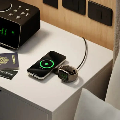 Smartfon i smartwatch na ładowarce indukcyjnej na stoliku nocnym w hotelu