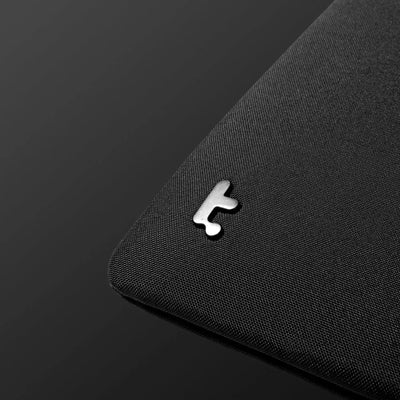 Czarna podkładka na biurko z metalowym logotypem, akcesorium do desk setupu