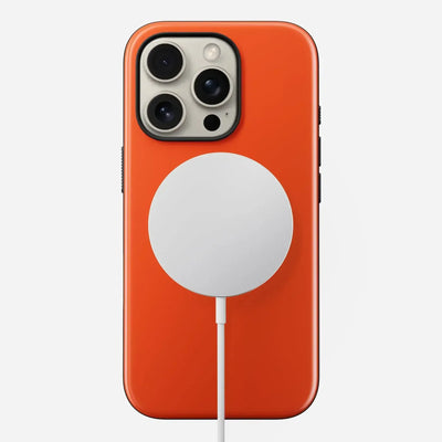 iPhone w pomarańczowym etui ładowany magnetyczną ładowarką bezprzewodową