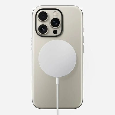 Smartfon ładowany bezprzewodowo ładowarką MagSafe, widok od tyłu, akcesoria do home office