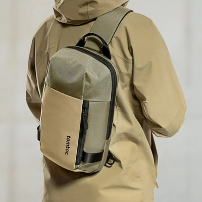 Beżowa torba na ramię typu sling, wodoodporna, nowoczesny design, osoba w kurtce
