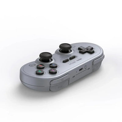 Bezprzewodowy szary gamepad retro z joystickami i przyciskami do komputera i konsoli