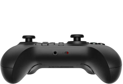 Czarny kontroler gamingowy z joystickami i gniazdem słuchawkowym, widok z tyłu