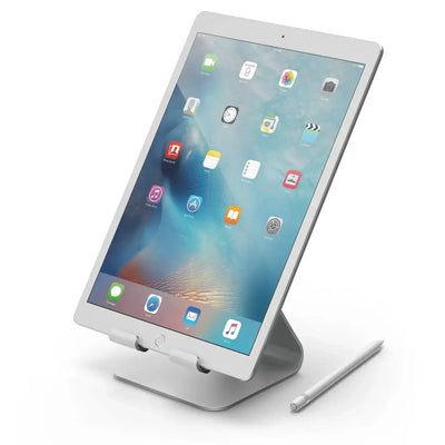 Tablet na aluminiowym stojaku biurkowym, obok leży rysik, akcesoria do home office