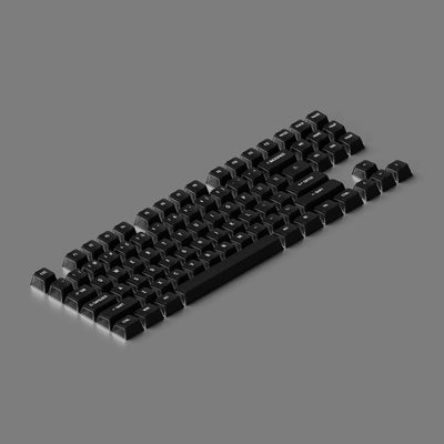 Czarne keycapy do klawiatury mechanicznej, zestaw na szarym tle, akcesoria biurowe