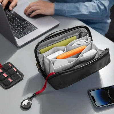 Organizer na akcesoria biurowe na biurku, w środku kable, dysk, pendrive, z boku laptop i telefon