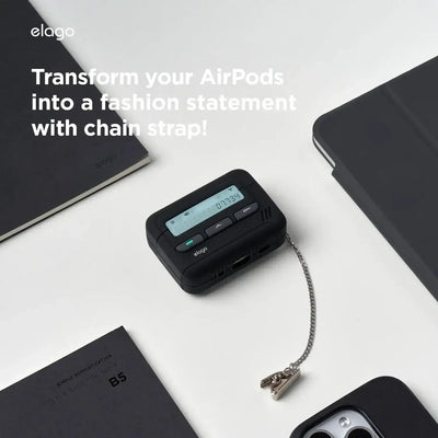 Czarny futerał na AirPods w stylu pagera z łańcuszkiem na biurku obok notebooka i telefonu