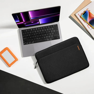Nowoczesny laptop na biurku z etui, smartfonem i dyskiem przenośnym, idealny desk setup.
